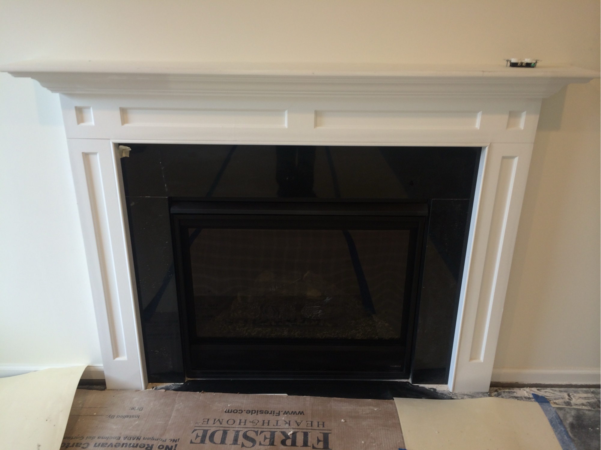Before: classic white mantel mid-construction with raw drywall surround